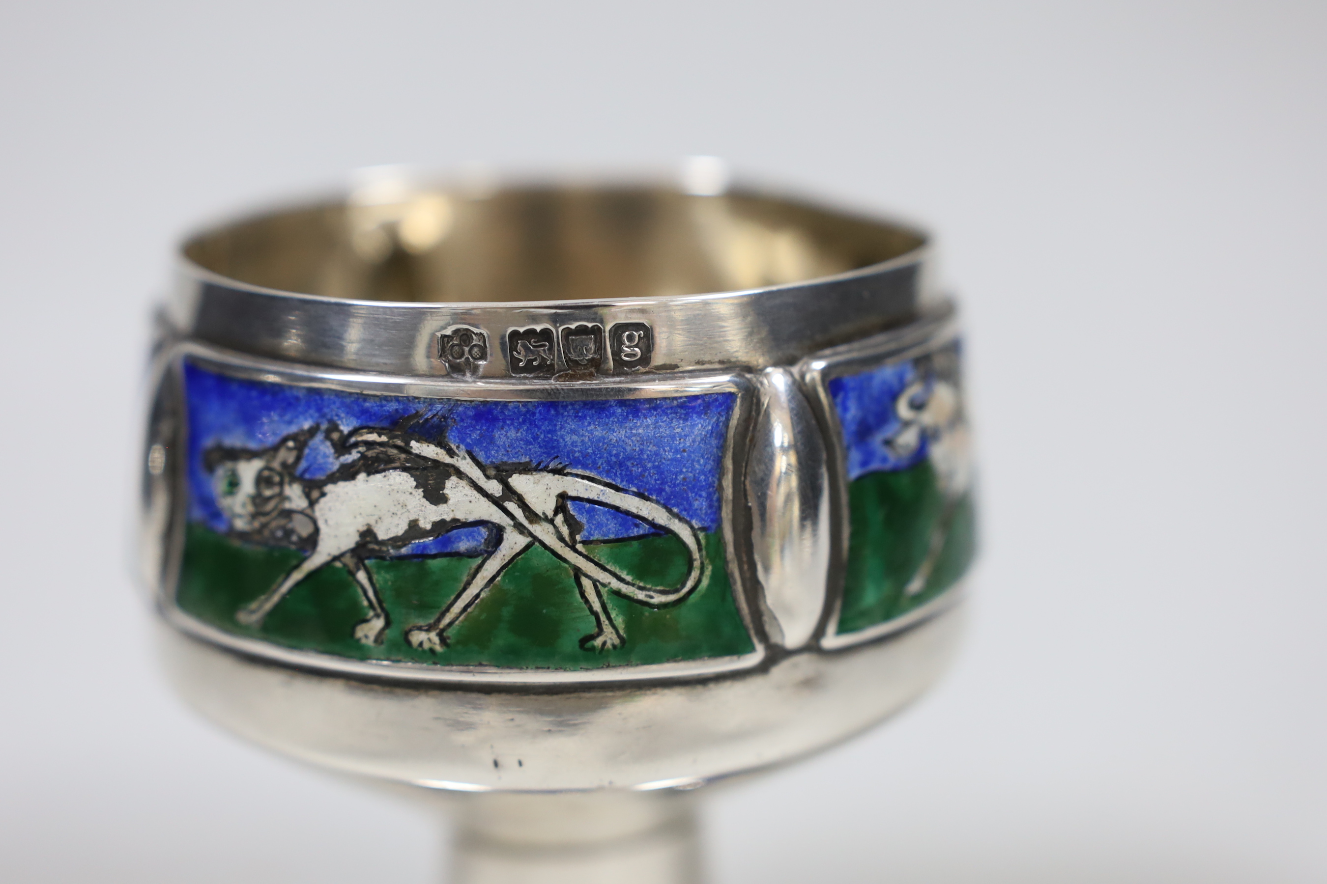 An Edwardian Arts and Crafts silver and enamel chalice, overstamped maker's mark, London, 1902, height 9.3cm, decorated with animals, on a beaded foot, gross 9.6oz.